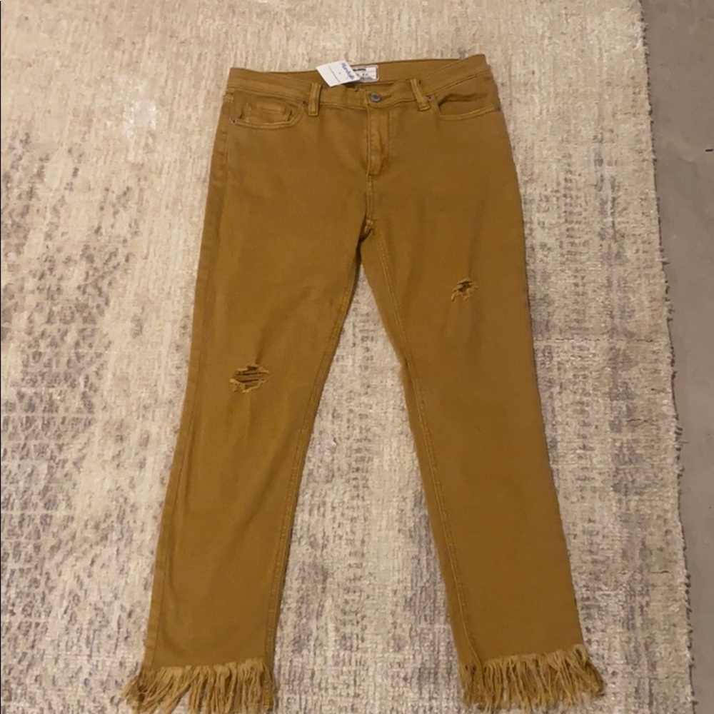 Light brown pants with fringe at bottom of legs